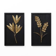 two black and gold wall hangings with flowers on them