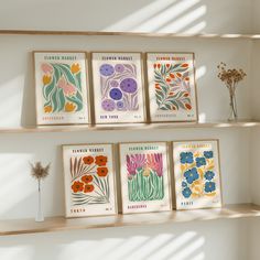 four framed flower prints on shelves in a room