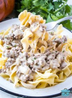 a white plate topped with pasta covered in gravy