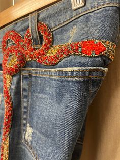 Roberto Cavalli Vintage Red Snake Jeans Rhinestone Beaded Denim. There are some places on the gold stripe that some beads are missing. No missing decoration on the red snake(please see photos). Made in Italy The measurements of the jeans are: Waist - 38cm Hips - 43cm Thigh -23cm Inseam - 82cm All measurements are done with the garment laying flat. Size XS Very Good Vintage Condition Please see pictures for more details. Please note that vintage items are not new and may have minor imperfections. For more details and information please send a personal message. You can ask me any question before buying. WORLDWIDE SHIPPING by  DHL Express Estimated time of arrival in 1-3 working days. Handling period 1 business day. * Please leave your phone number. It is for the DHL waybill.  * Without the p Red Monkey Jeans, Snake Jeans, Roberto Cavalli Vintage, Beaded Denim, Balmain Bag, Rhinestone Jeans, Red Snake, Jean Vintage, Rhinestone Bead