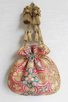 a small purse with tassels hanging from it's side on a wall