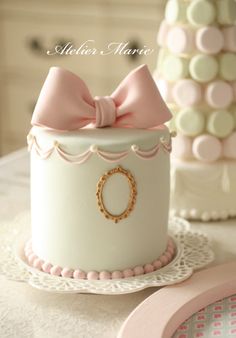 there is a white cake with a pink bow on it