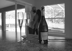 two champagne flutes and a bottle of wine on a counter