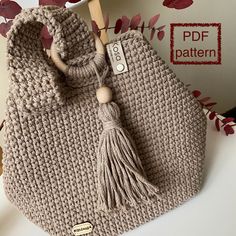 a crocheted purse with a wooden handle and tassel