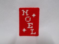 a close up of a red and white piece of cloth with the word love spelled in small letters