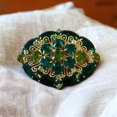 Stunning Verified Juliana Delizza And Elster Green Domed Oval Shaped Brooch With Colors Of Dark Emerald And Peridot Pale Green And Emerald Green Crystal Chaton And Navette Cut Rhinestones And Gold Plated Prong Settings With A Filigree Design. Verified Via Is It Juliana Website Reference Number 6072. Would Be A Beautiful Gift For A May Birthday. As With Any Vintage Or Preowned Item, One Should Expect A Scuff Or Light Scratch Here And There, Or Other Reasonable Signs Of Use Over Time. Sometimes A Little Cleaning Will Be Needed. I Will Always Point Out Any Obvious Damage Or Other Issues That Might Prevent The Intended Use Of An Item You Purchase From Me. Items May Not Appear The Exact Colors Emerald Green Crystal, Juliana Jewelry, May Birthday, Green Oval, Filigree Design, Green Crystal, Green Crystals, Pale Green, Emerald Green