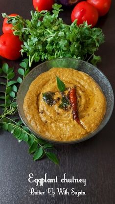 a bowl filled with hummus next to some tomatoes and parsley on the side