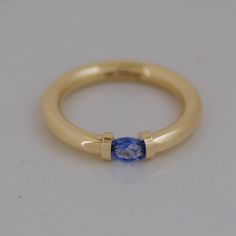 a yellow gold ring with a blue sapphire stone