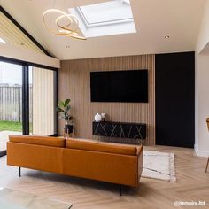 a living room filled with furniture and a flat screen tv mounted to the side of a wall