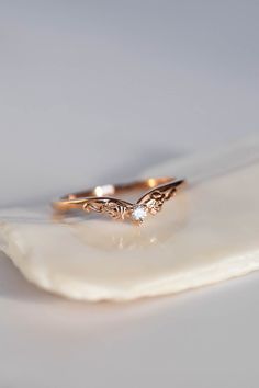 a close up of a gold ring on top of a seashell with a white background