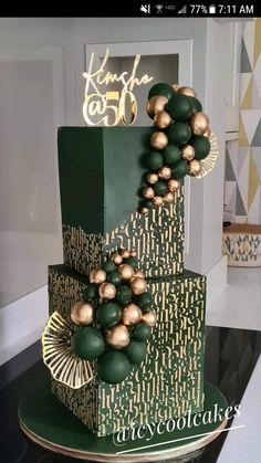 a three tiered cake with gold and green decorations