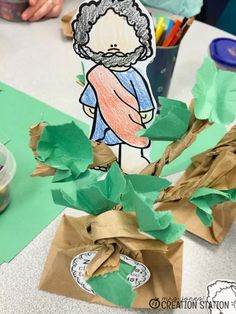 a child's hand is on top of a tree made out of brown paper