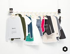 clothes hanging on a rack in front of a white wall