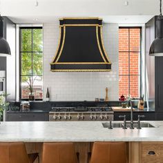 a kitchen with an oven, stove and chairs in front of the counter top area