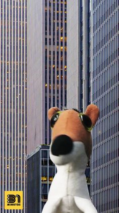 a large stuffed animal in the middle of a city with tall buildings behind it,