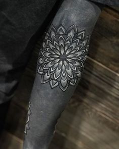 a man's leg with a tattoo on it that has a large flower in the middle