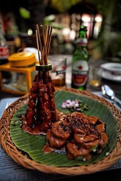 a plate topped with meat and vegetables on top of a wooden table next to bottles