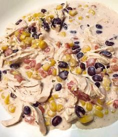 a white plate topped with black beans, corn and chicken meat mixture on top of it