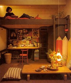 a woman sitting on top of a bunk bed next to a desk and chair in a room