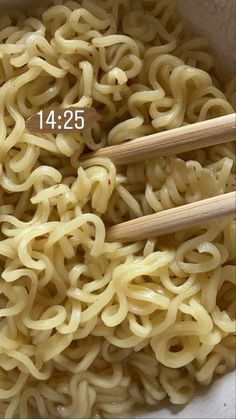 two wooden chopsticks in a bowl of noodles