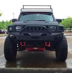 the front end of a black jeep parked in a parking lot