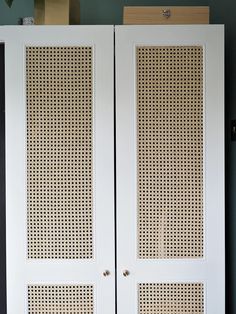 two white doors with perfored panels on the front and back sides in a room