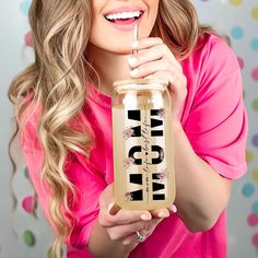 a woman in pink shirt holding up a jar with the word vegan on it