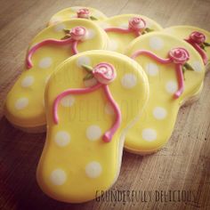 decorated cookies with pink and white polka dots are on a wooden table, ready to be eaten