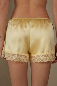 Silk shorts with lace trim. The model is 5'9 and is wearing size S.

Silk, the most noble and finest of natural fibres, is also one of the most durable. Enveloping and keeping you warm in winter, but light to wear in summer, silk allows your skin to breathe. Our vast range of 100% silk designs offer the perfect solution for everyone who prefers a sophisticated look without sacrificing comfor t. Sublime noble fibres for day or night. Satin Camisole With Built-in Bra For Loungewear, Summer Silk Sleepwear With Lace Trim, Nighttime Satin Sleepwear With Built-in Bra, Solid Color Camisole Sleepwear With Built-in Bra, Playful Yellow Sleepwear Set, Silk Set, Silk Shorts, Silk Pajamas, Pastel Yellow