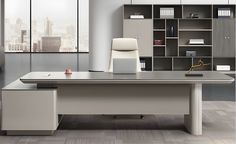 an office desk with a chair and bookcases in front of the window,