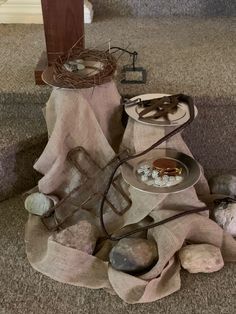 an assortment of items sitting on the floor next to a table with a bird's nest