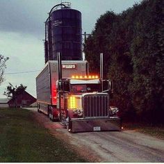 a large semi truck driving down a dirt road