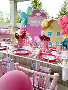 a table set up with pink and blue decorations