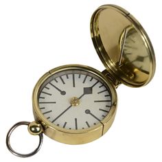 a gold pocket watch with a white face