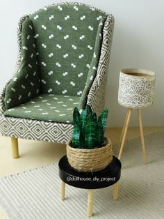 a green chair sitting next to a small potted plant