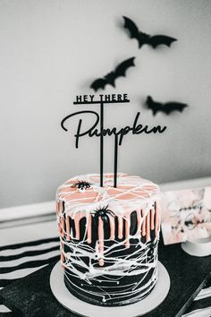 there is a cake that has been decorated with icing and bats on the table