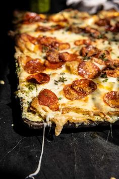 a square pizza with pepperoni and cheese on it's side sitting on a table