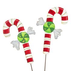 two candy canes decorated with green and red candies on top of each other