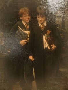 two young boys dressed in harry potter robes, one holding a fan and the other wearing a top hat