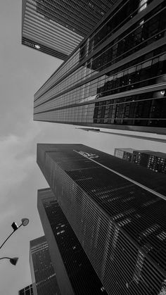 black and white photograph of skyscrapers in new york city with street lights at the bottom