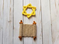 two crocheted objects are sitting on a white wooden surface, one is yellow and the other is brown