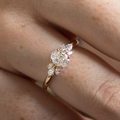 a woman's hand with a diamond ring on top of her finger and an engagement band