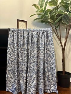 a blue and white table with a potted plant next to it on a wooden floor