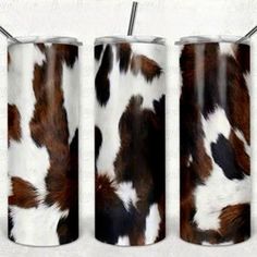 three tumbles with brown and white cow print on them, one is holding a straw