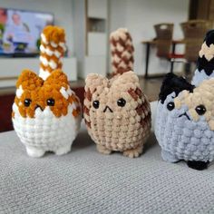 four small crocheted animals sitting on top of a table