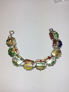 "This is a very colorful enameled Sterling silver link bracelet. Each shield link is approximately 1/2\" hooked together with Sterling jump rings. The enameling is in very good vintage condition with very little wear. It is signed B.M. Co. Sterling. It measures 7\" long. It has a spring ring closure. Any questions, please email me." Vintage Multicolor Enamel Jewelry, Vintage Black Enamel Bracelet Jewelry, Adjustable Vintage Enamel Bracelets, Vintage Black Enamel Bracelet, Vintage Multicolor Enamel Bangle, Baby Rings, Silver Link Bracelet, Hand Ring, Shield Design