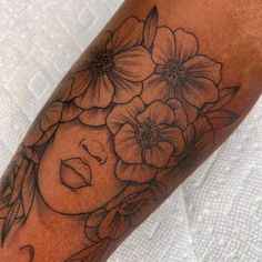 a woman's face with flowers on her arm