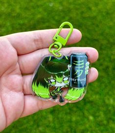 a hand holding a green and black cell phone case with an anime character on it