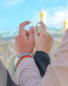 two people are holding rings in their hands