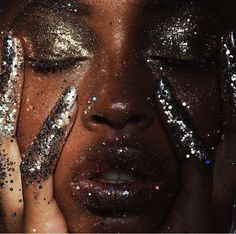 a woman with glitter on her face and hands